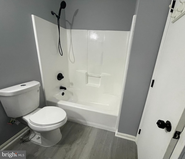 bathroom featuring shower / bath combination, hardwood / wood-style floors, and toilet