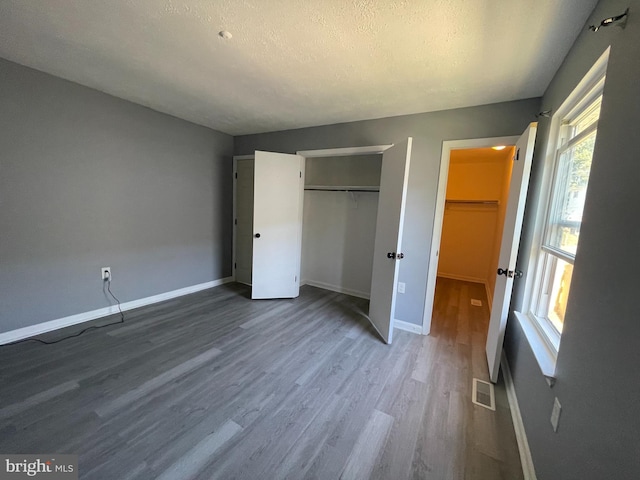 unfurnished bedroom featuring wood-type flooring and a textured ceiling