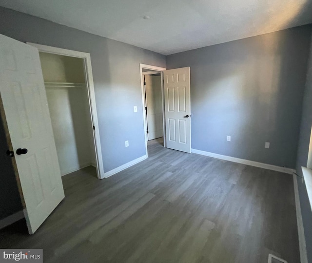 unfurnished bedroom with hardwood / wood-style flooring and a closet