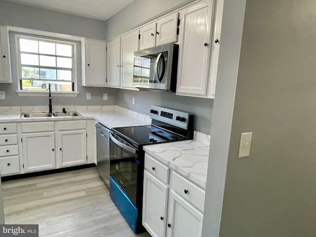 kitchen featuring light hardwood / wood-style flooring, sink, stainless steel appliances, and white cabinets