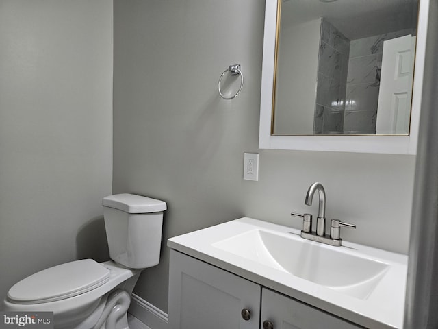 bathroom with vanity, toilet, and a tile shower