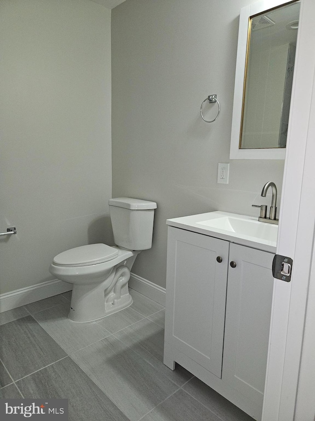 bathroom with vanity, toilet, and tile patterned flooring