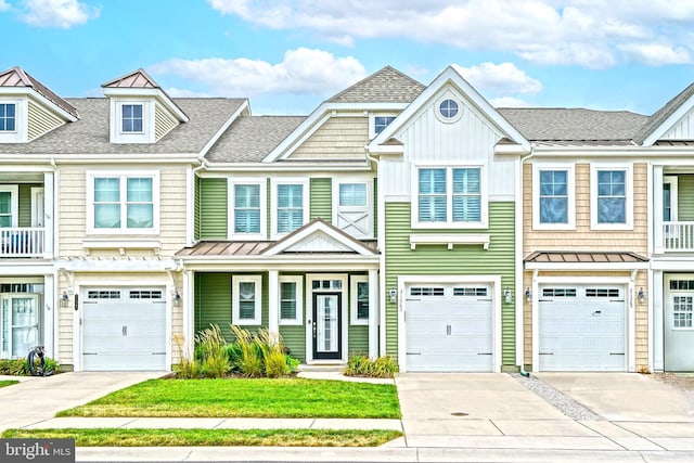 multi unit property featuring driveway, a shingled roof, metal roof, a standing seam roof, and board and batten siding