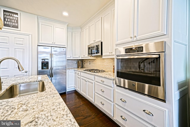 kitchen featuring dark hardwood / wood-style flooring, stainless steel appliances, sink, and white cabinets