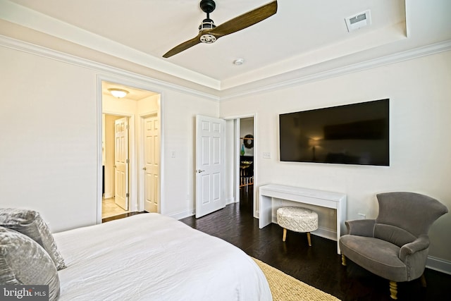 bedroom featuring crown molding, dark wood-type flooring, a raised ceiling, and ceiling fan