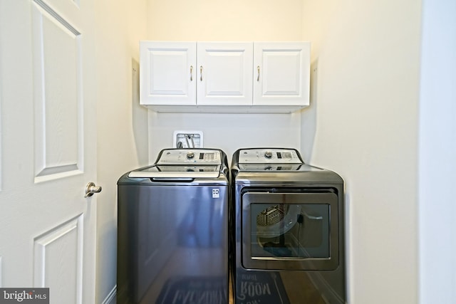 clothes washing area with cabinets and washing machine and dryer