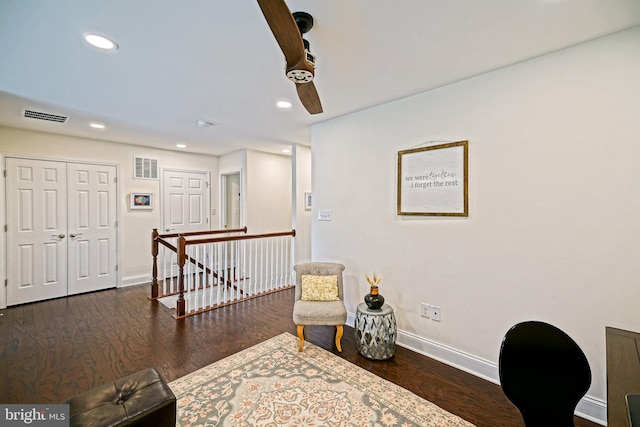 living area with dark hardwood / wood-style flooring and ceiling fan