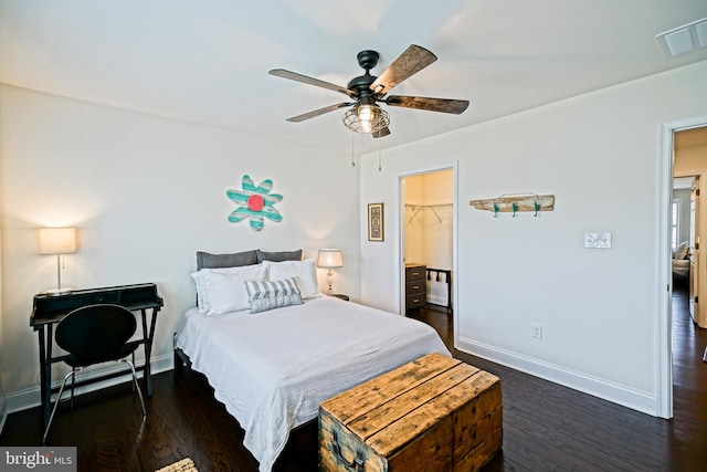 bedroom with a closet, ceiling fan, dark hardwood / wood-style floors, and a spacious closet