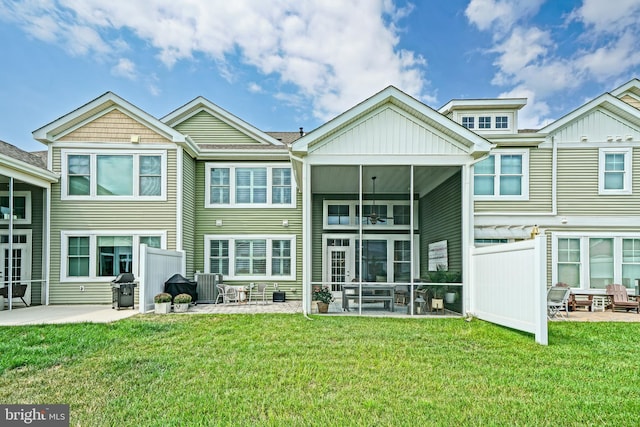 back of house featuring a yard, a patio area, and a sunroom