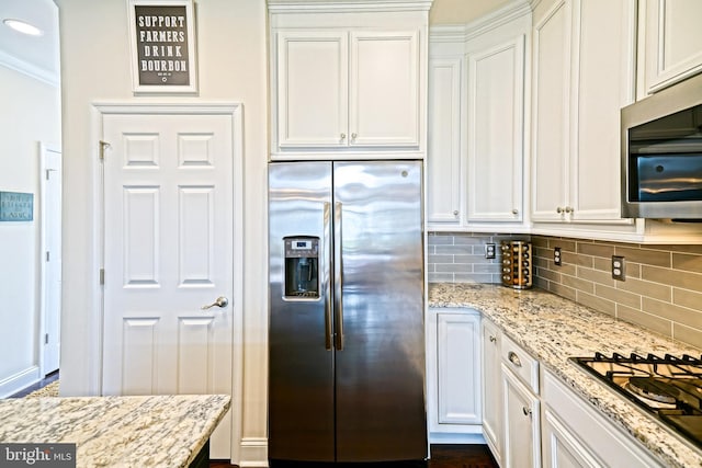 kitchen featuring crown molding, stainless steel appliances, light stone counters, and white cabinetry