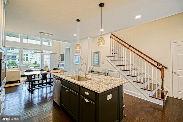 kitchen featuring dishwasher, dark hardwood / wood-style floors, a kitchen island with sink, and sink