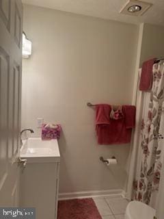 bathroom with vanity, toilet, and tile patterned flooring