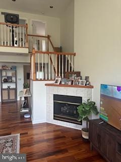 living room with dark wood-type flooring and a fireplace