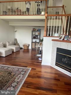 living room with a tile fireplace and wood-type flooring