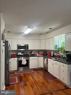 kitchen featuring stainless steel appliances, white cabinetry, and dark hardwood / wood-style flooring