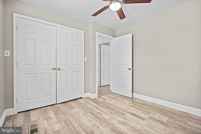 unfurnished bedroom with light hardwood / wood-style flooring, a closet, and ceiling fan