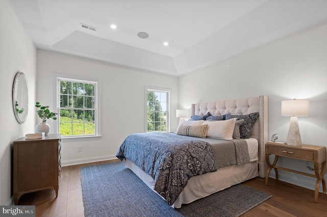 bedroom featuring dark wood-type flooring and a tray ceiling