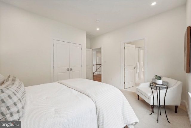 bedroom featuring light carpet and a closet