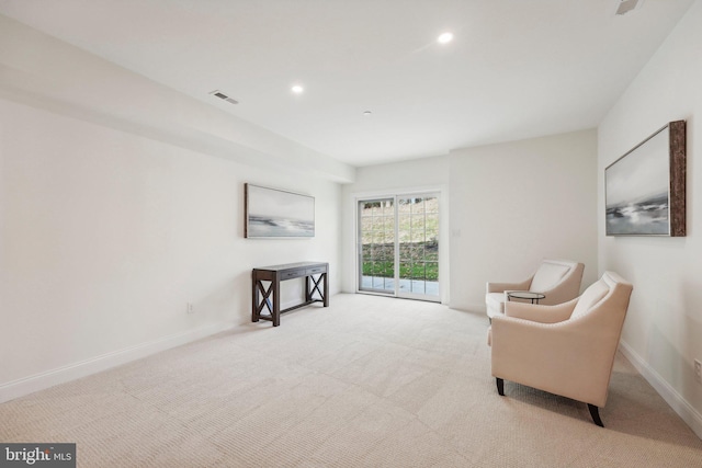 sitting room featuring light carpet