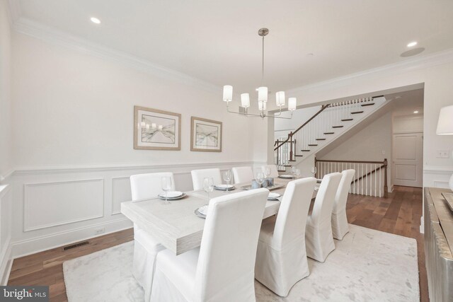 kitchen featuring wall chimney range hood, a center island, white cabinets, and stainless steel appliances