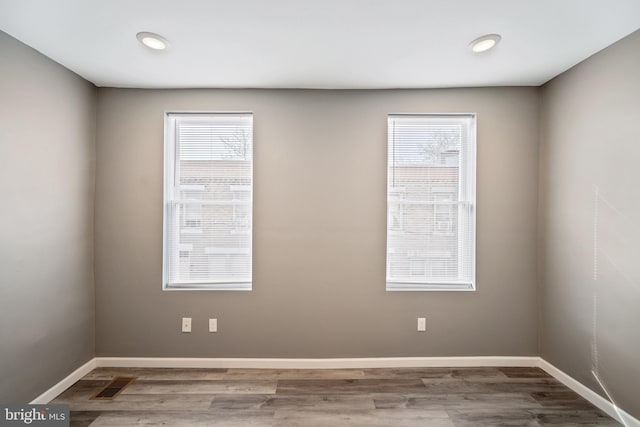 spare room featuring hardwood / wood-style flooring and plenty of natural light