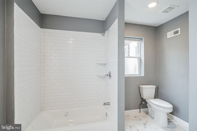 bathroom featuring tiled shower / bath and toilet