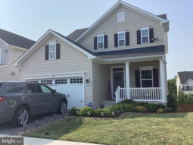 view of front property with covered porch, a garage, and a front lawn