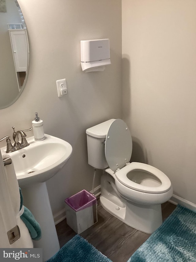 bathroom featuring sink, hardwood / wood-style floors, and toilet