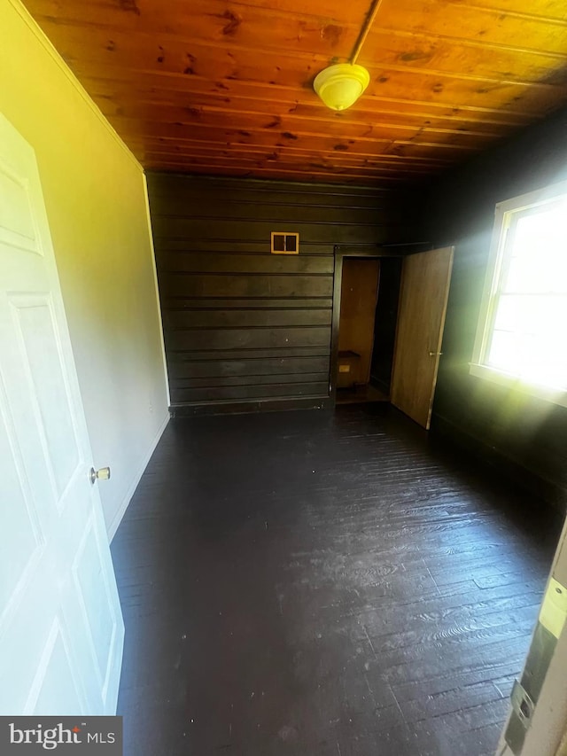 interior space featuring dark hardwood / wood-style floors and wood ceiling