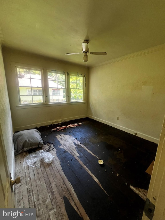 empty room featuring ceiling fan, hardwood / wood-style flooring, plenty of natural light, and ornamental molding