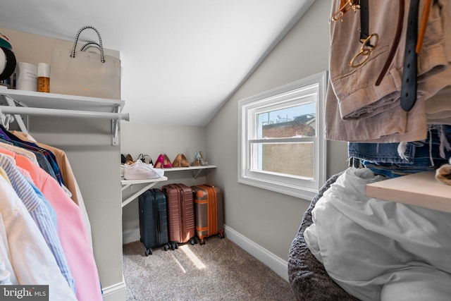 walk in closet with vaulted ceiling and carpet