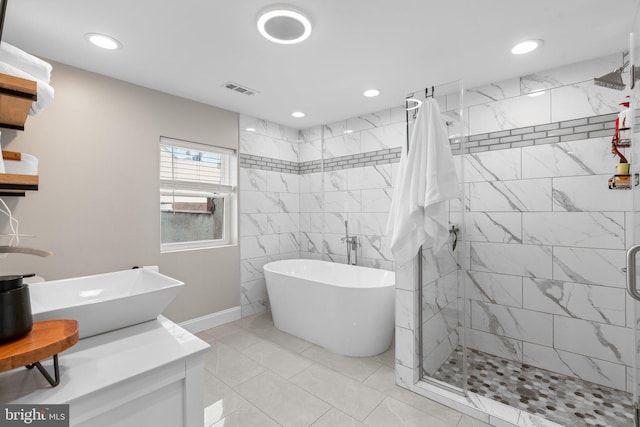 bathroom with separate shower and tub and dual sinks