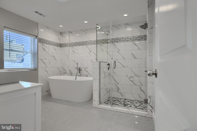 bathroom featuring shower with separate bathtub and tile walls