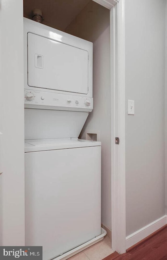 laundry room featuring stacked washer and dryer, laundry area, and baseboards