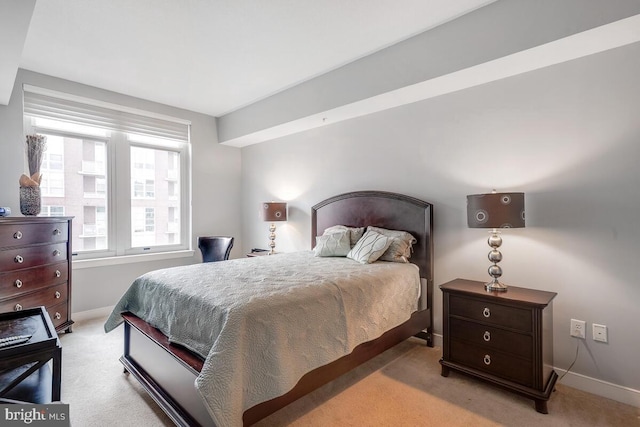 bedroom featuring light carpet and baseboards