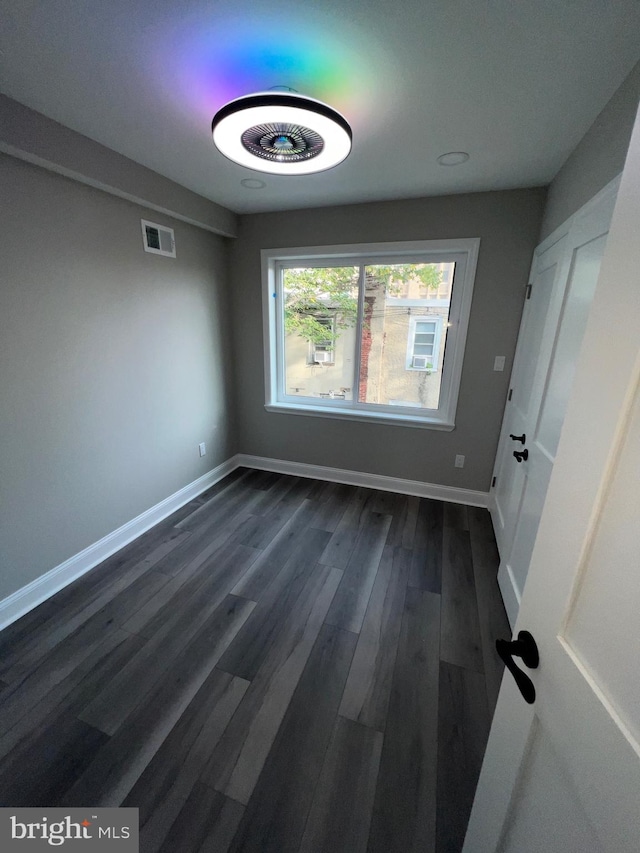 unfurnished room with dark hardwood / wood-style flooring