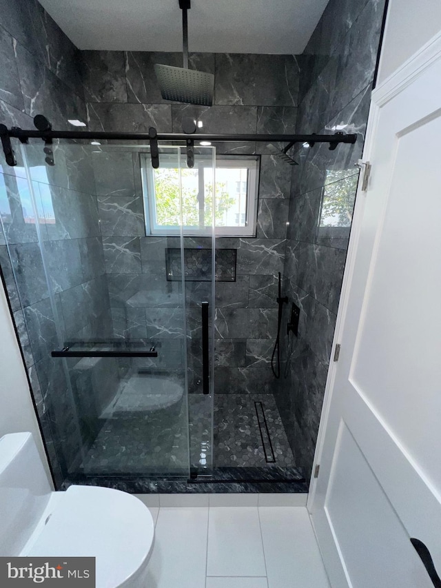 bathroom with tile patterned floors, toilet, and an enclosed shower