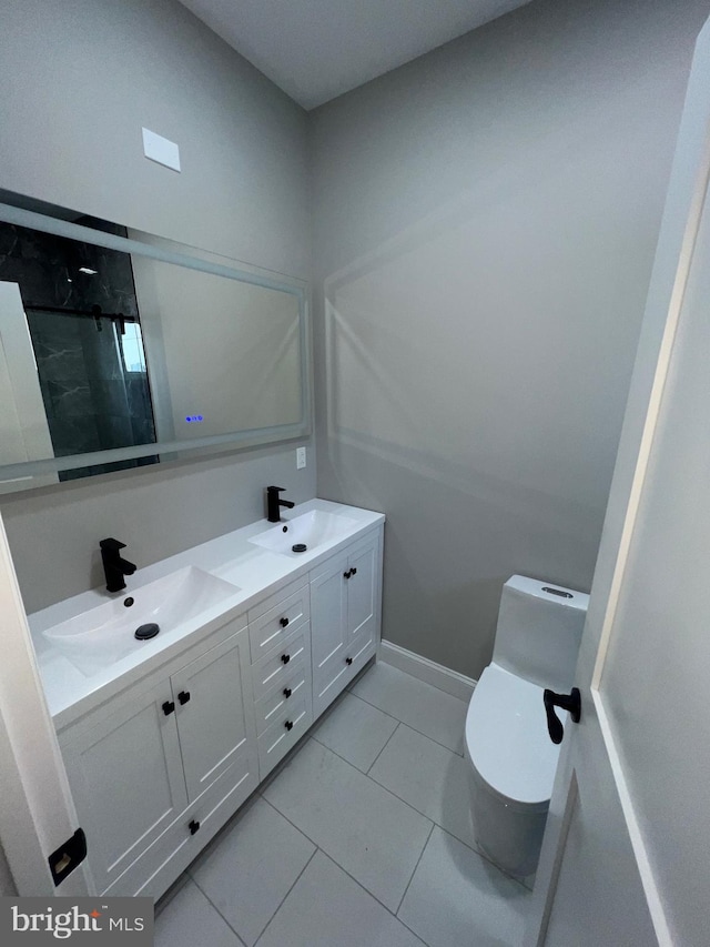 bathroom featuring vanity, toilet, tile patterned floors, and tiled shower