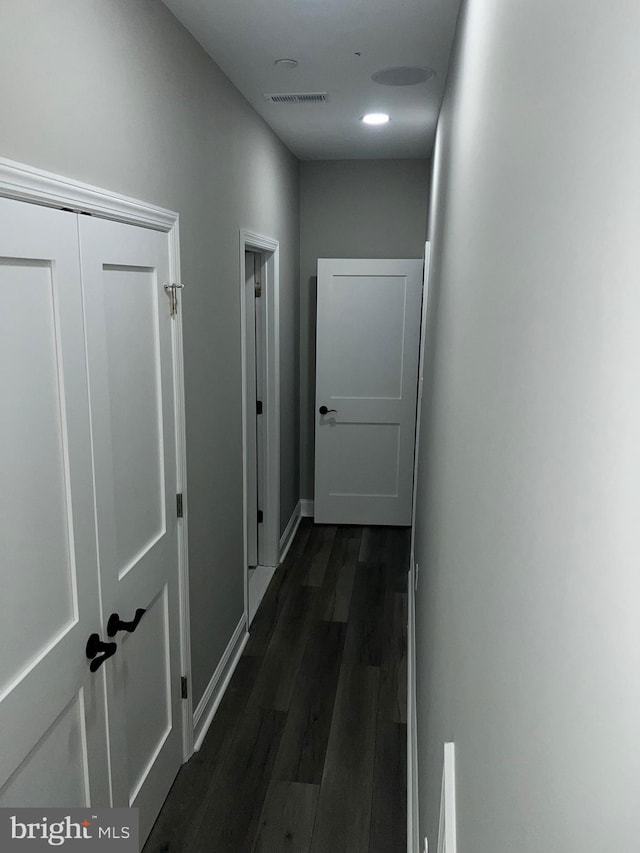 corridor with dark hardwood / wood-style flooring