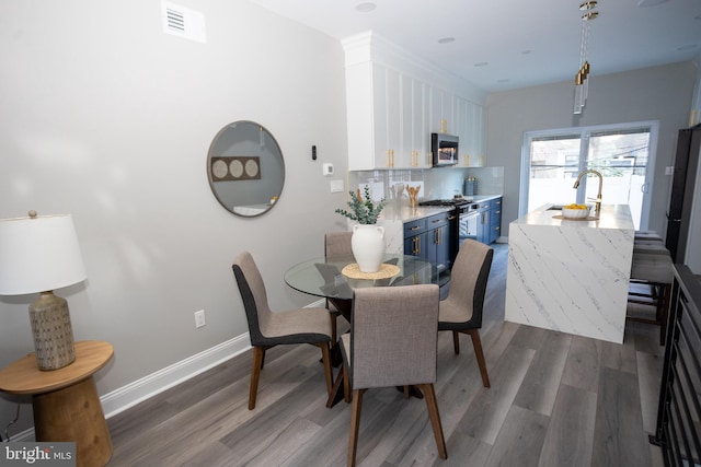 dining space featuring sink and dark hardwood / wood-style flooring