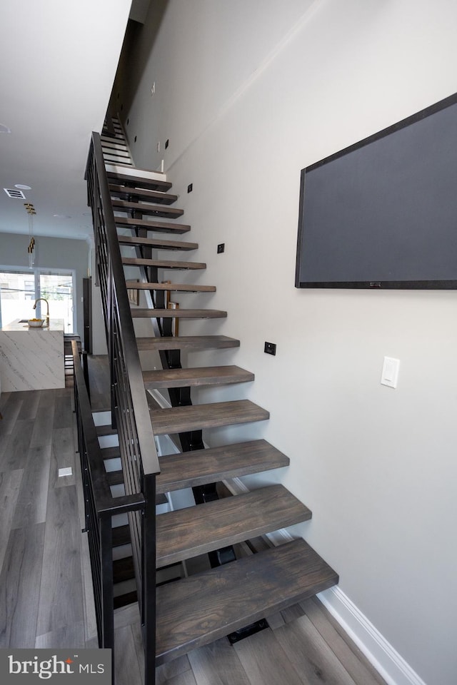 stairs featuring hardwood / wood-style floors