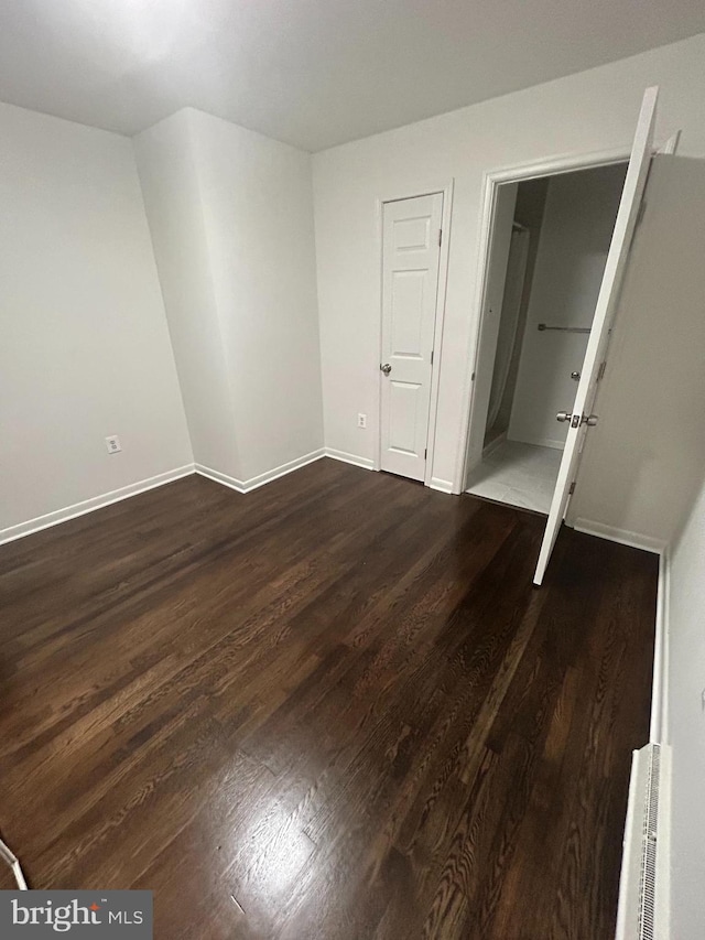 unfurnished bedroom featuring dark wood-type flooring