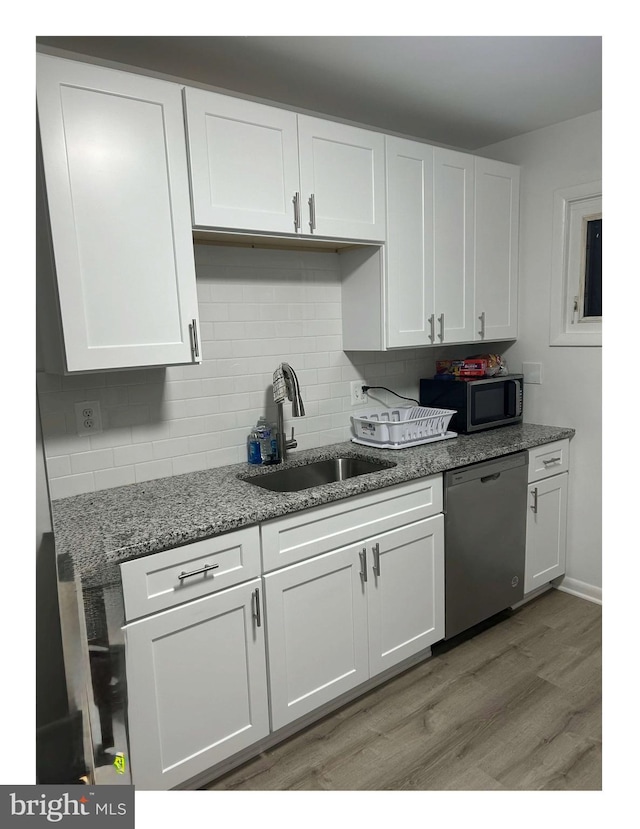 kitchen featuring white cabinetry, sink, stainless steel appliances, and light hardwood / wood-style floors