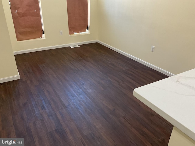 unfurnished room with dark hardwood / wood-style flooring