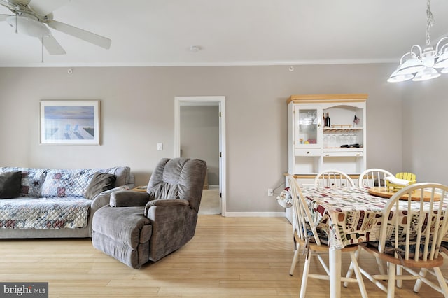 dining space with ceiling fan, light wood-type flooring, and ornamental molding