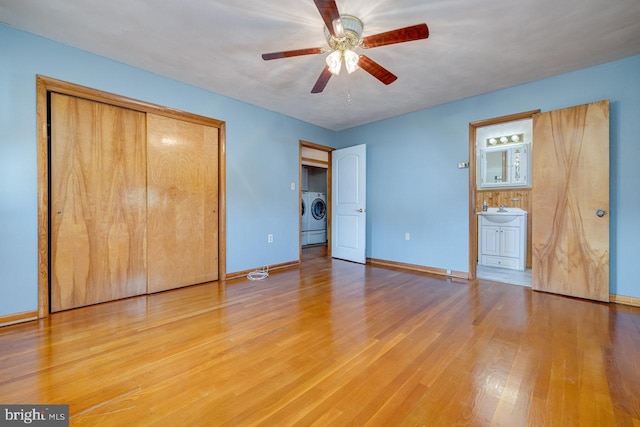 unfurnished bedroom with a closet, light hardwood / wood-style floors, washer and dryer, ensuite bath, and ceiling fan