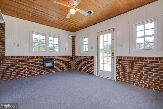 interior space with wood ceiling, plenty of natural light, heating unit, and ceiling fan