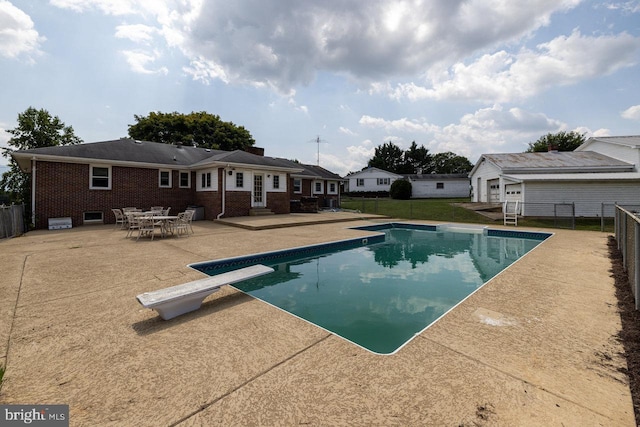 view of pool featuring a diving board and a patio