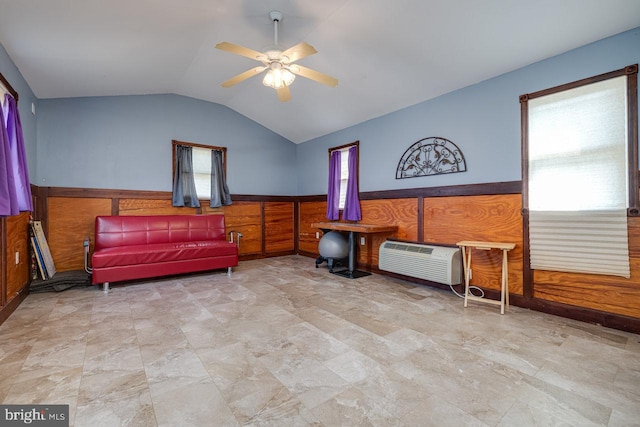 sitting room with a wall unit AC, lofted ceiling, ceiling fan, and light tile patterned floors