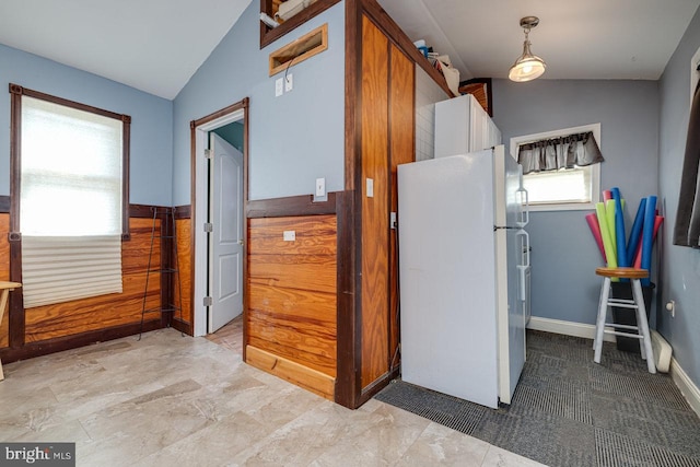 kitchen with white fridge, vaulted ceiling, and tile patterned flooring